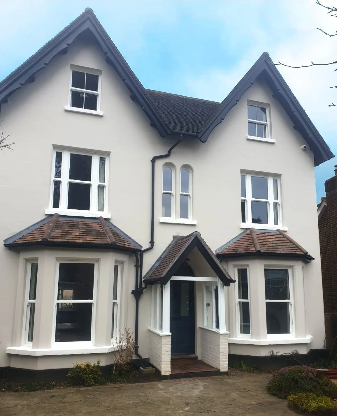 White sliding sash windows in a rendered period villa