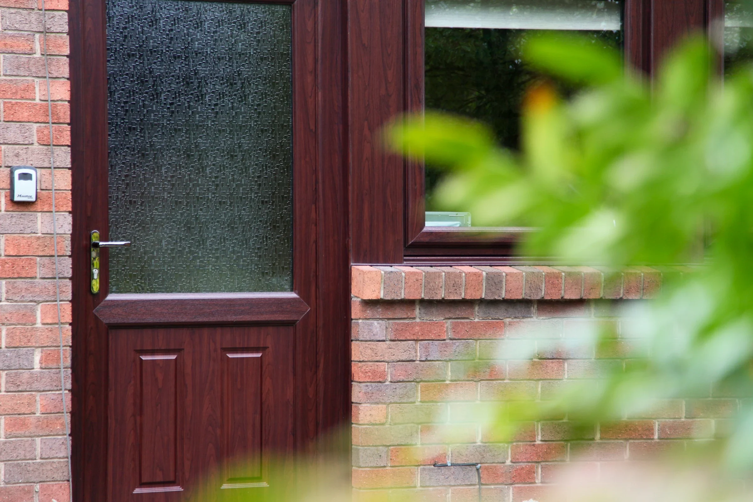 Rosewood-effect uPVC residential door with glazed upper panel