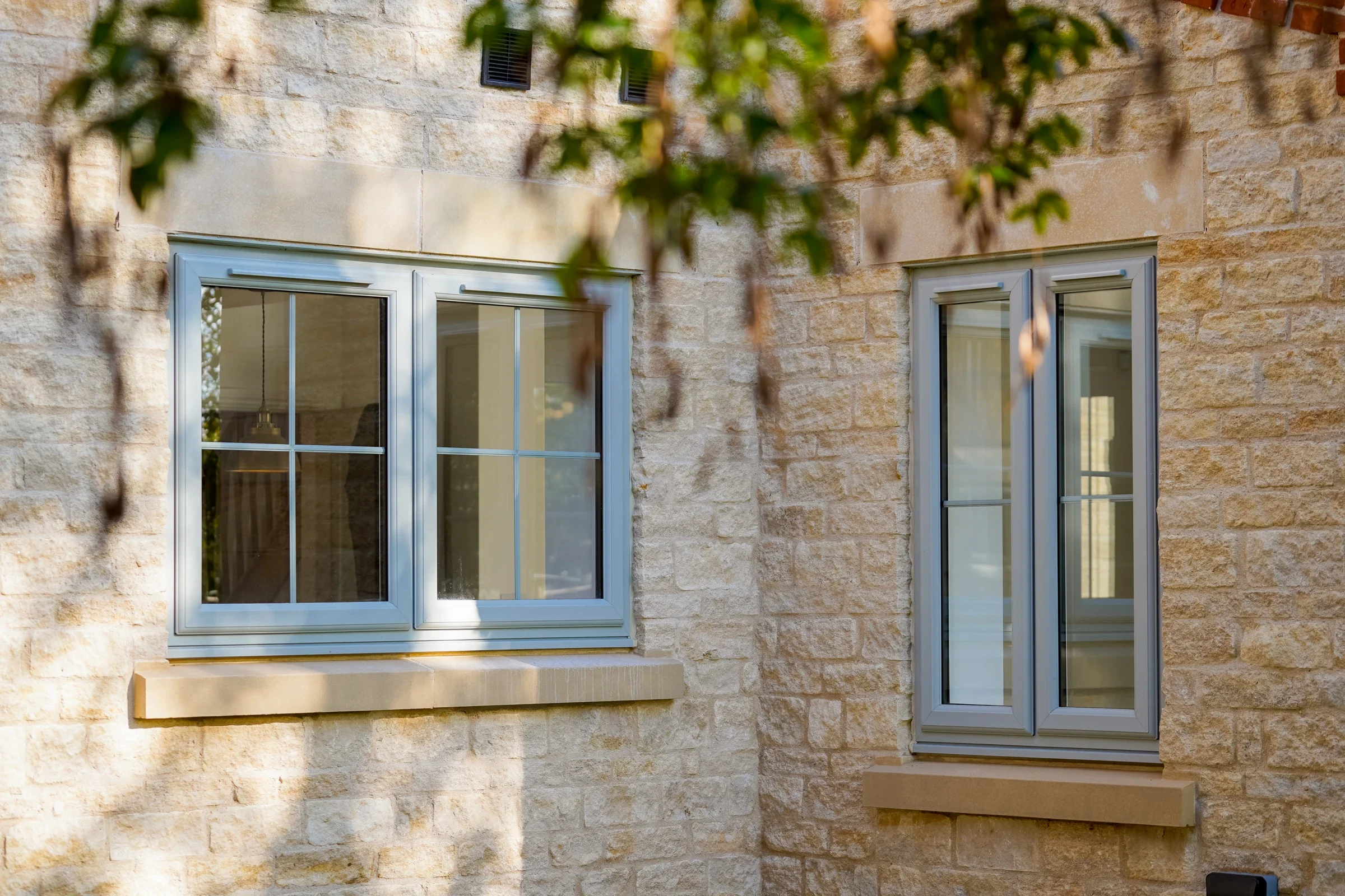 Agate grey uPVC casement windows in a stone house
