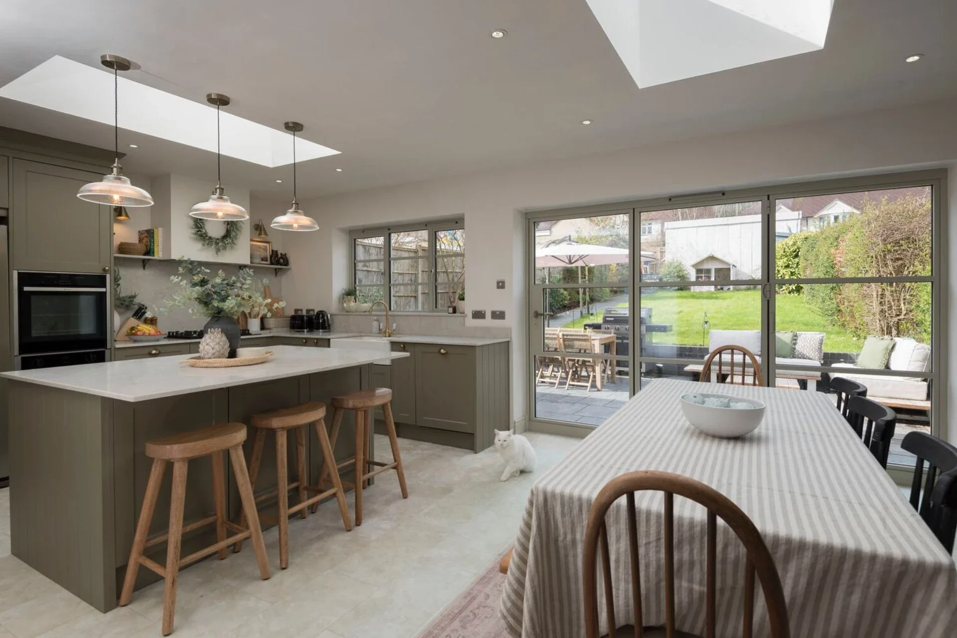 Grey heritage bifold doors in a furnished kitchen and dining space