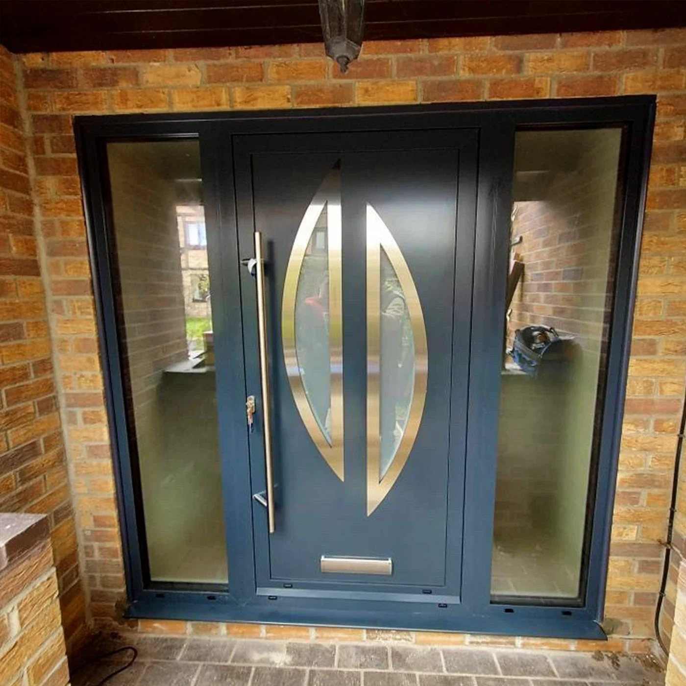 Dark aluminium front door with full-height glazed sidelights