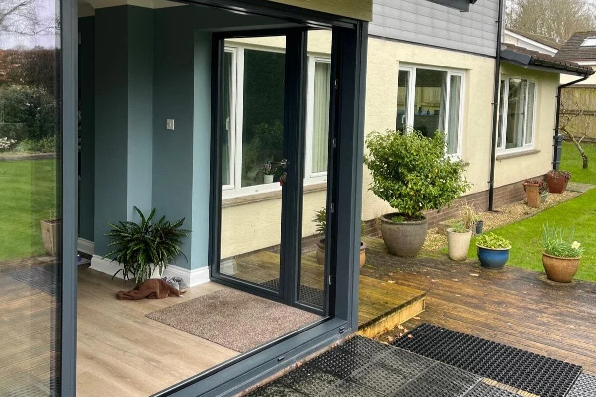 Exterior view of aluminium lift-and-slide doors in a garden extension