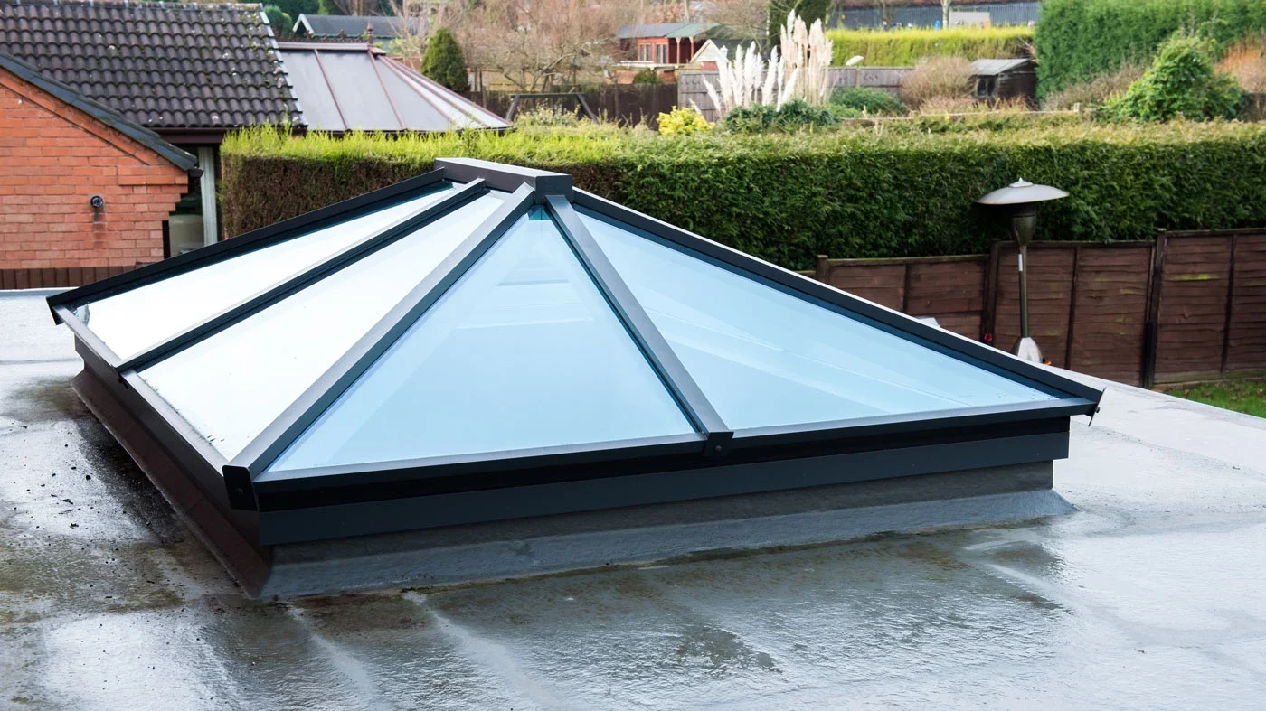 Dark aluminium roof lantern viewed from above on a flat-roof extension