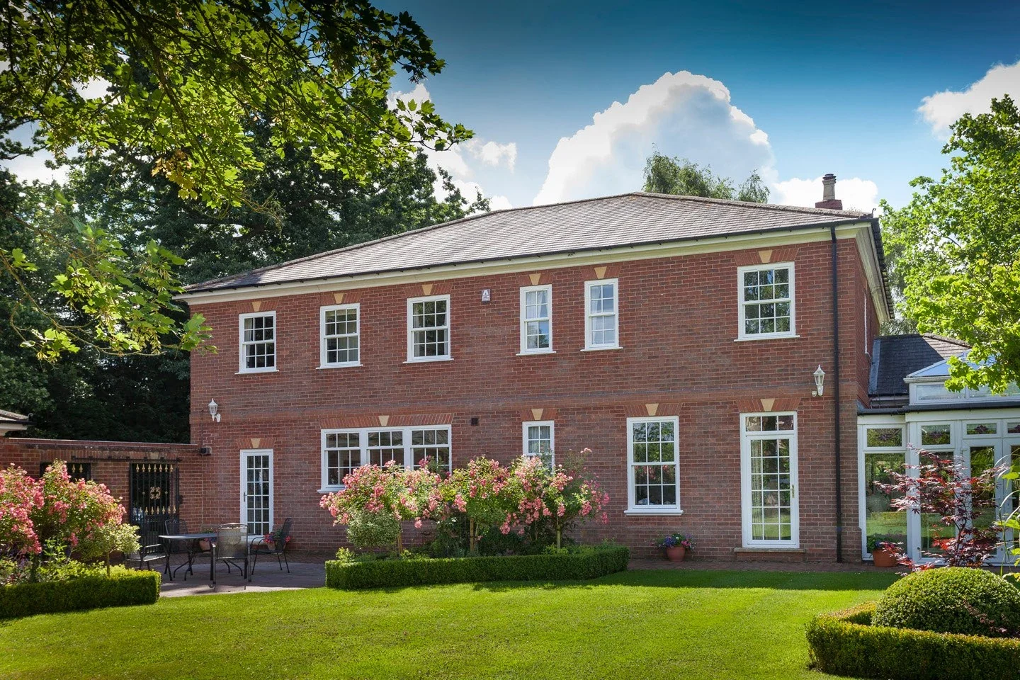 White uPVC sliding sash windows on a red-brick British country house
