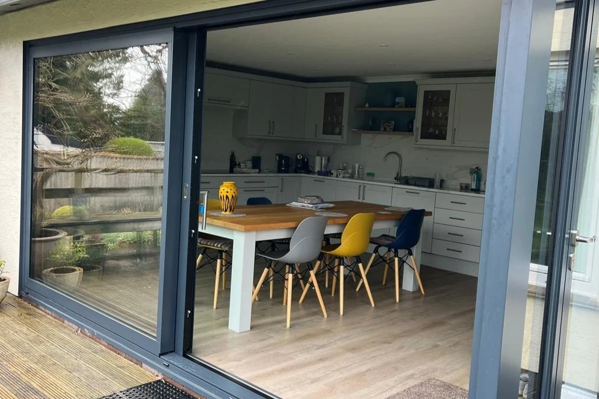 View through aluminium lift-and-slide doors into a kitchen