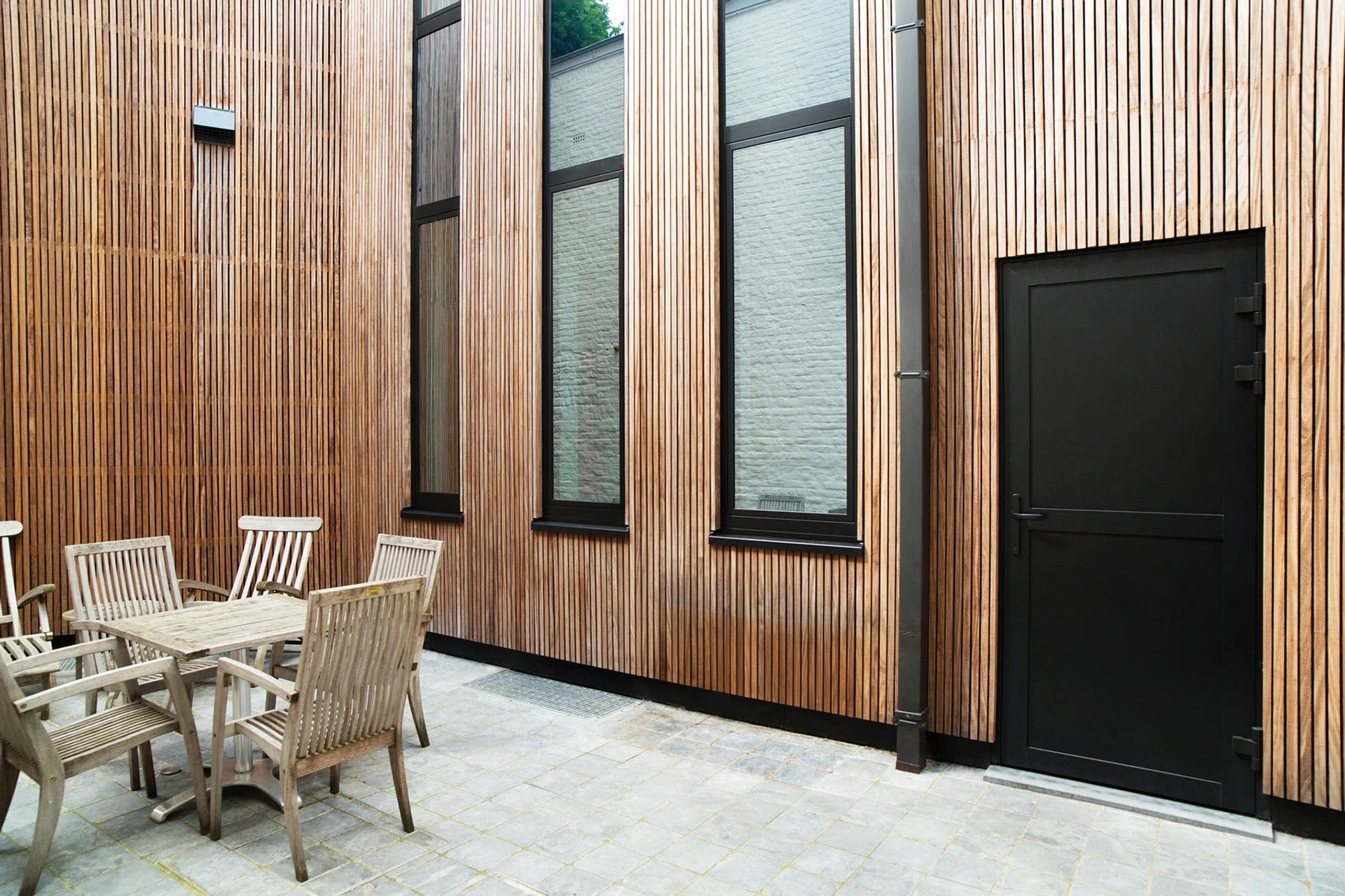 Tall aluminium tilt-and-turn windows in a timber-clad house