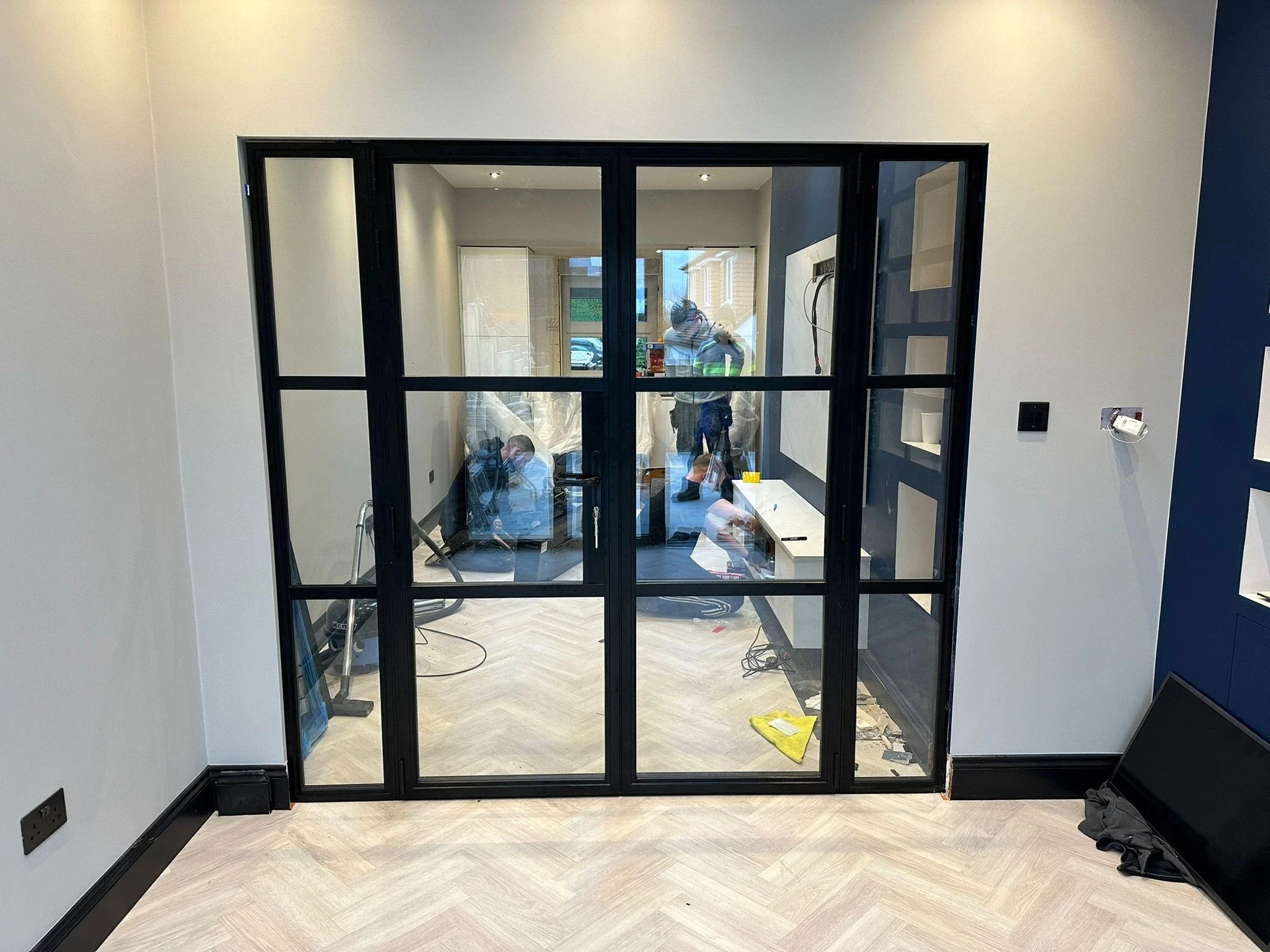 Black internal aluminium glazed screen with a single opening door