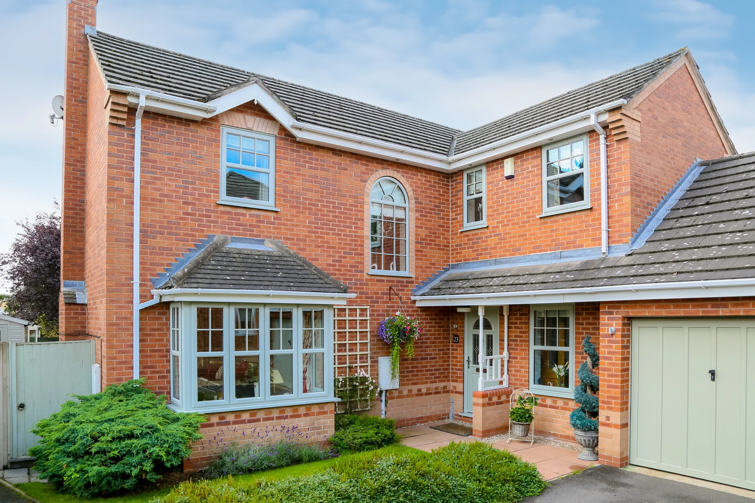 Agate grey uPVC casement windows on a red brick detached home