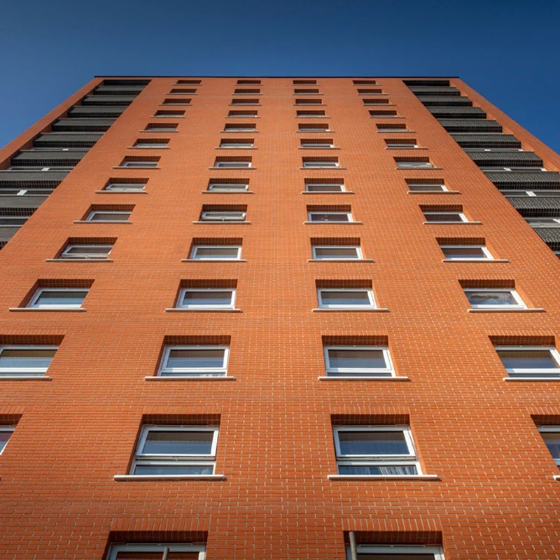 White fully reversible uPVC windows on a red brick apartment tower