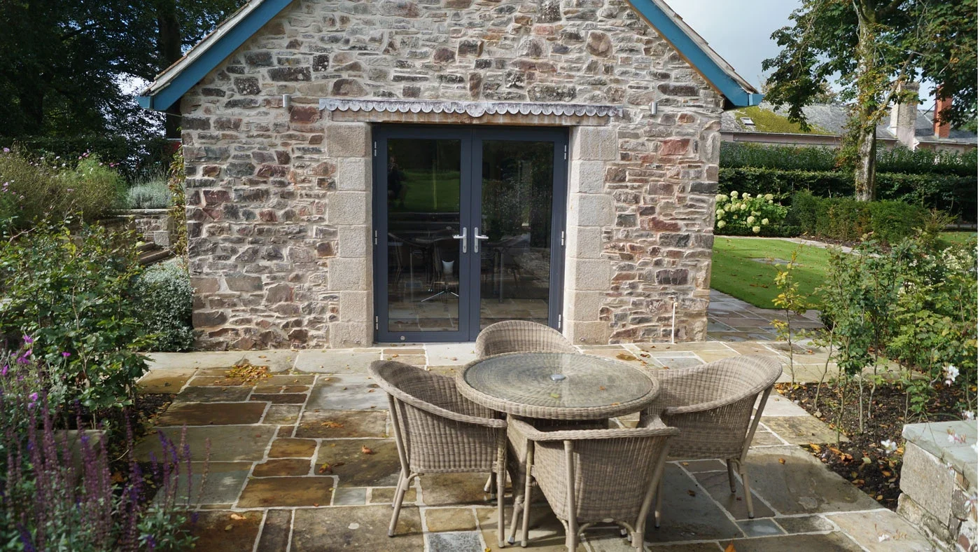 Dark aluminium French doors in a stone garden extension