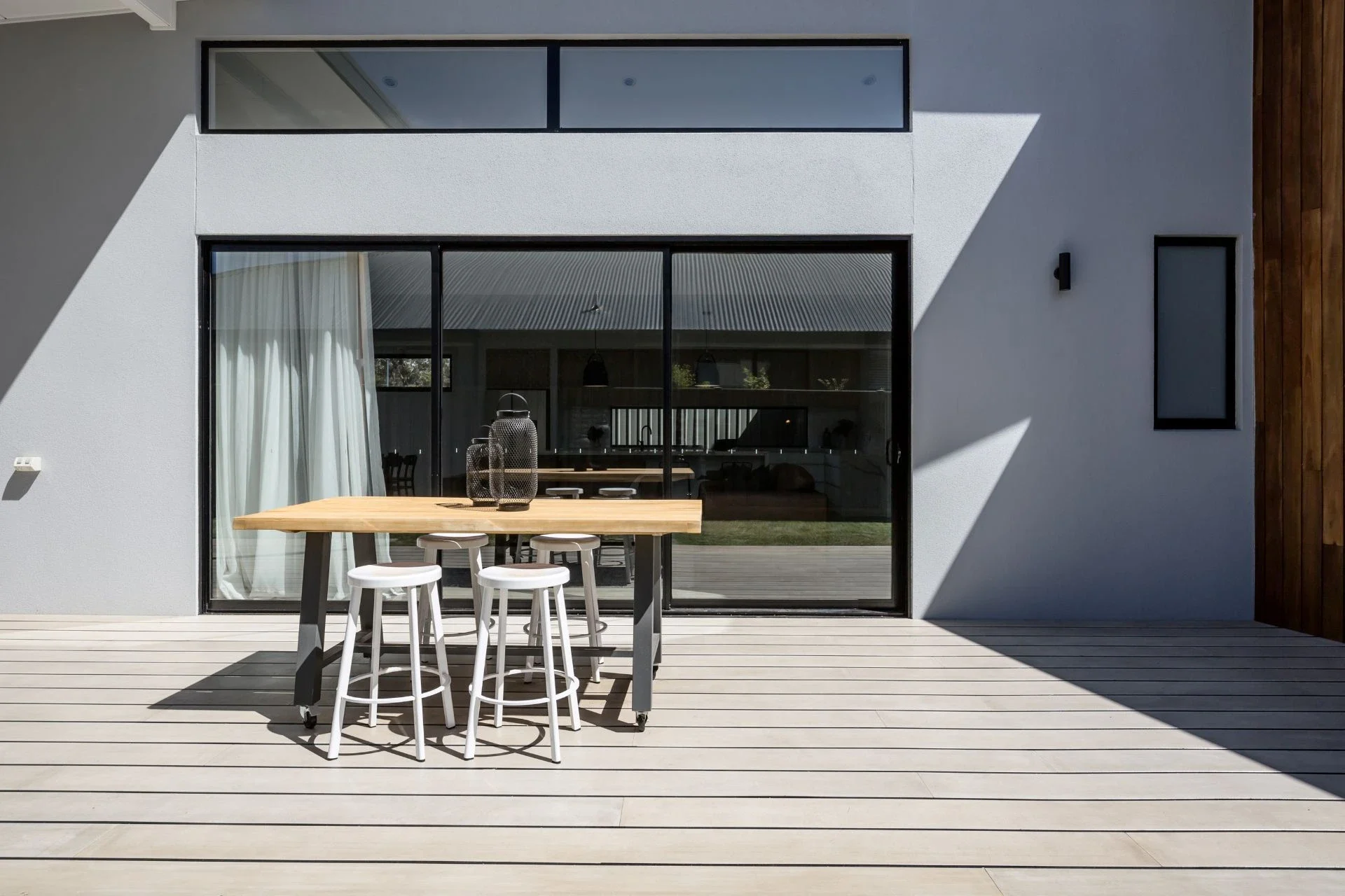 Slim aluminium sliding doors in a white-rendered garden elevation