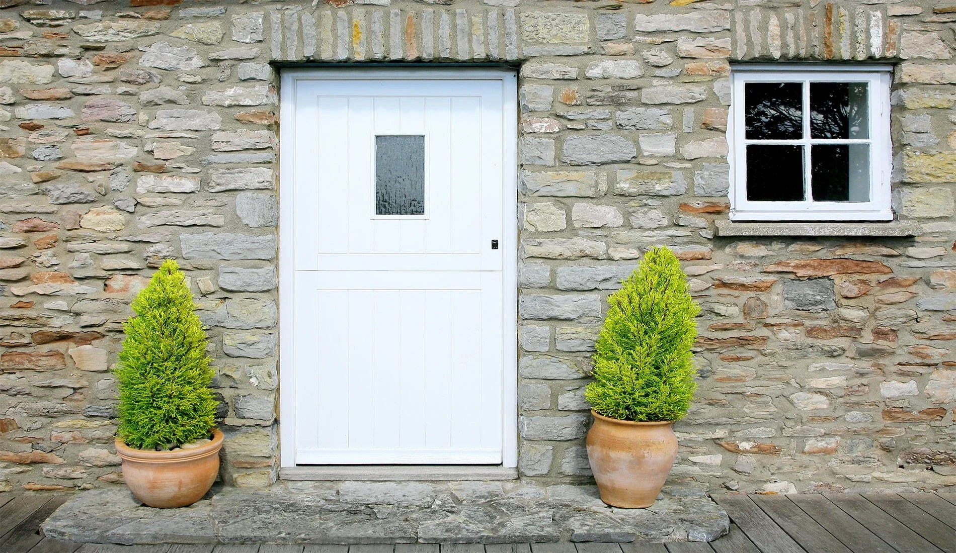 White uPVC stable door in a stone cottage wall