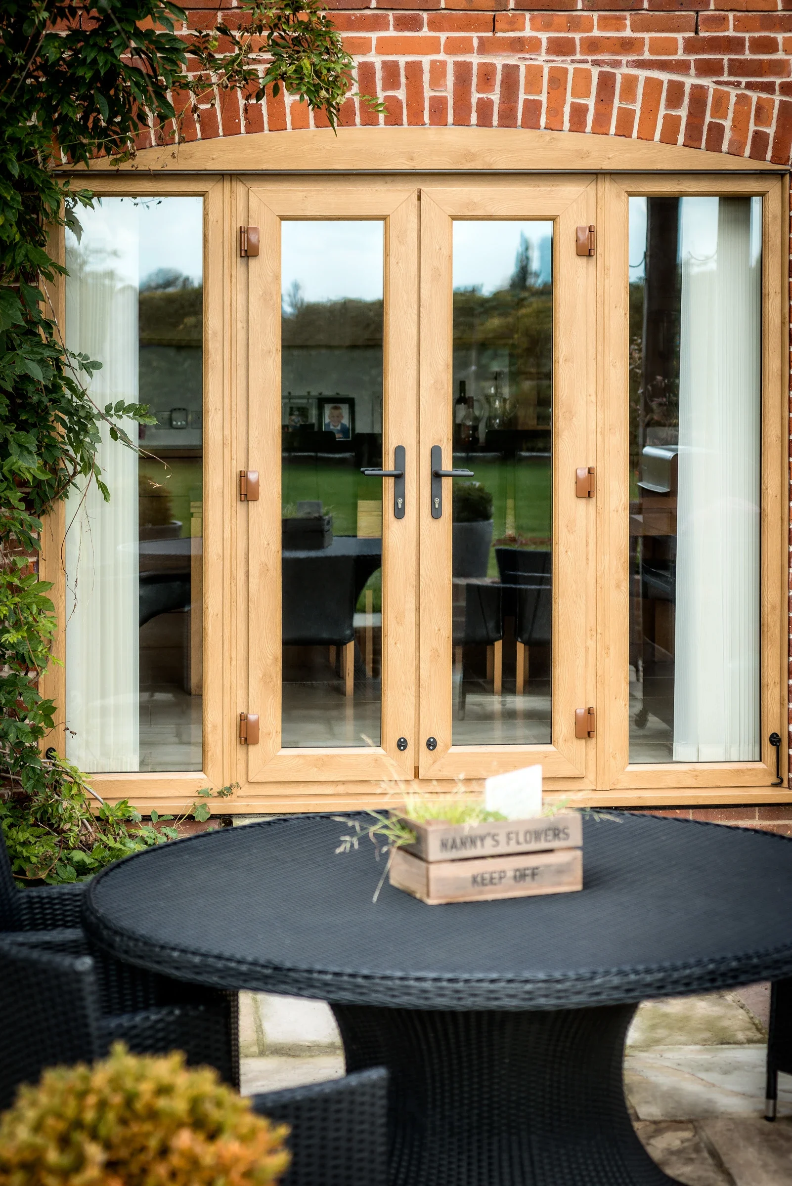 Oak-effect uPVC French doors opening onto a garden terrace