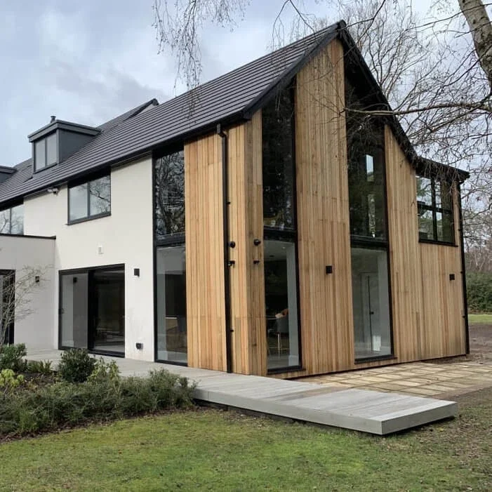 Flush aluminium windows in a timber-clad and white-rendered home