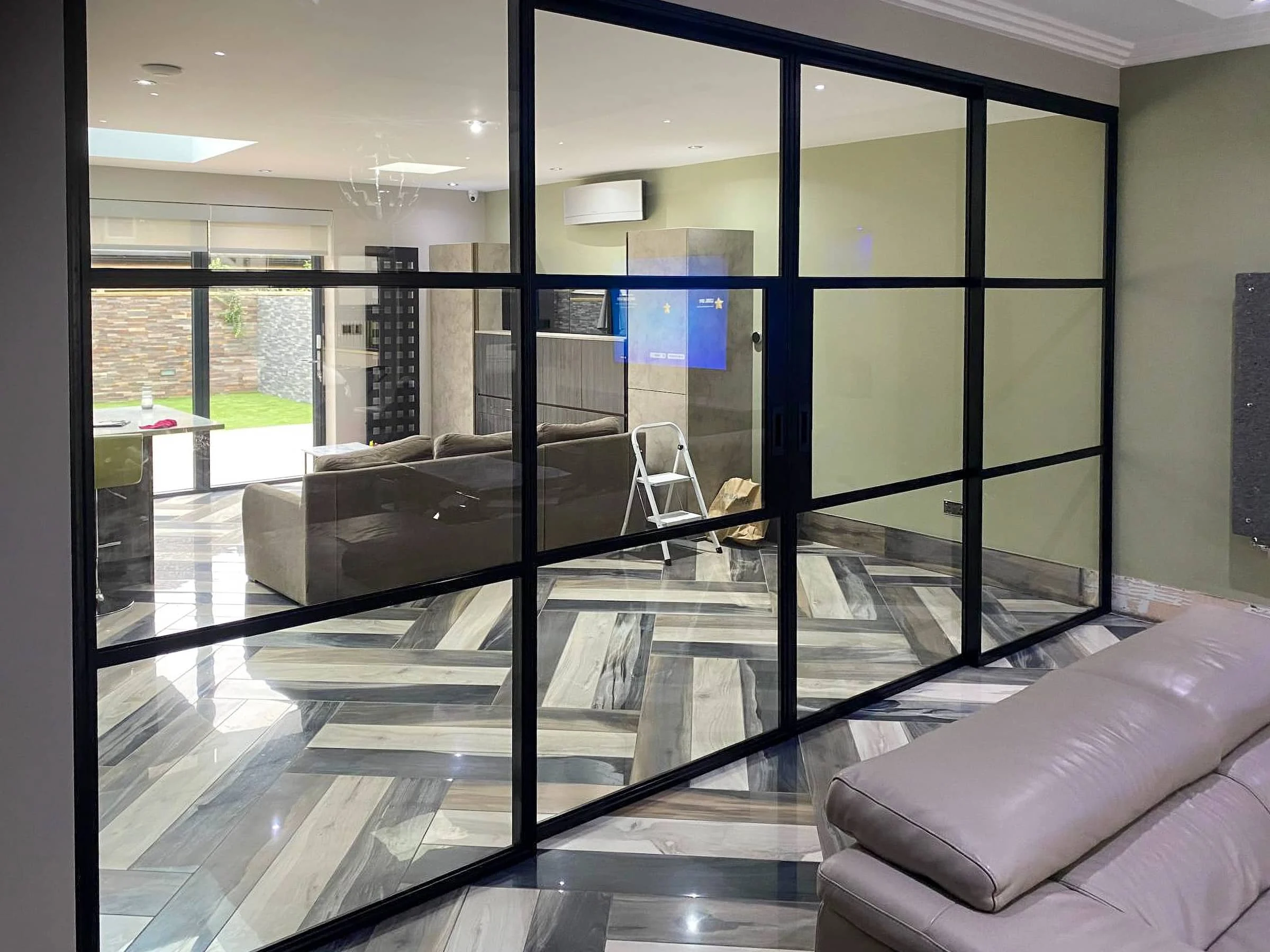 Black internal sliding doors dividing furnished rooms in an Ilford home