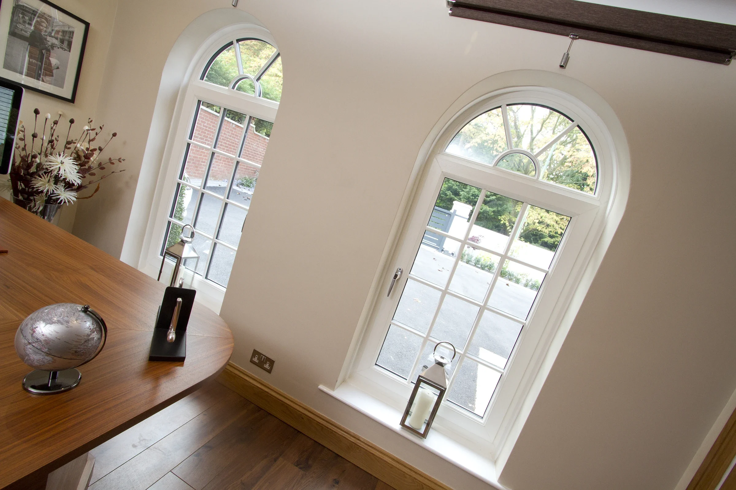 Arched white uPVC tilt-and-turn windows in a dining room