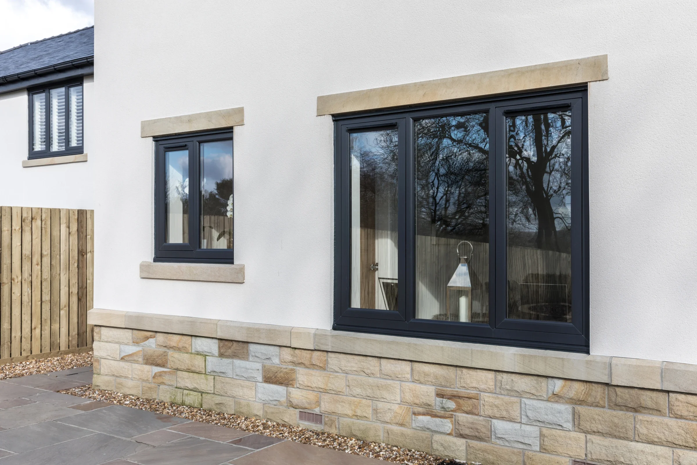 Dark flush uPVC casement windows in a rendered home