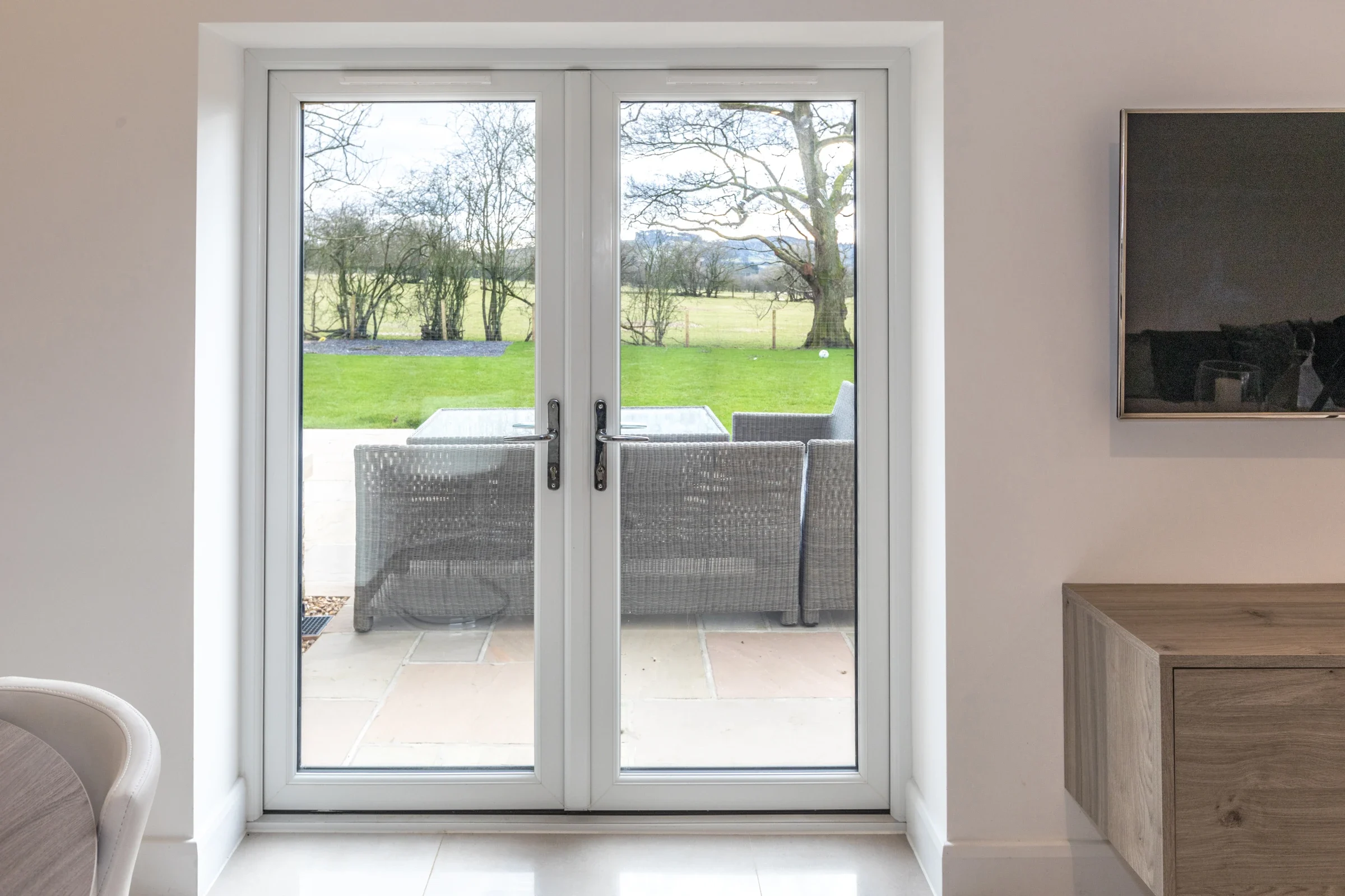 White uPVC French doors viewed from a bright living room