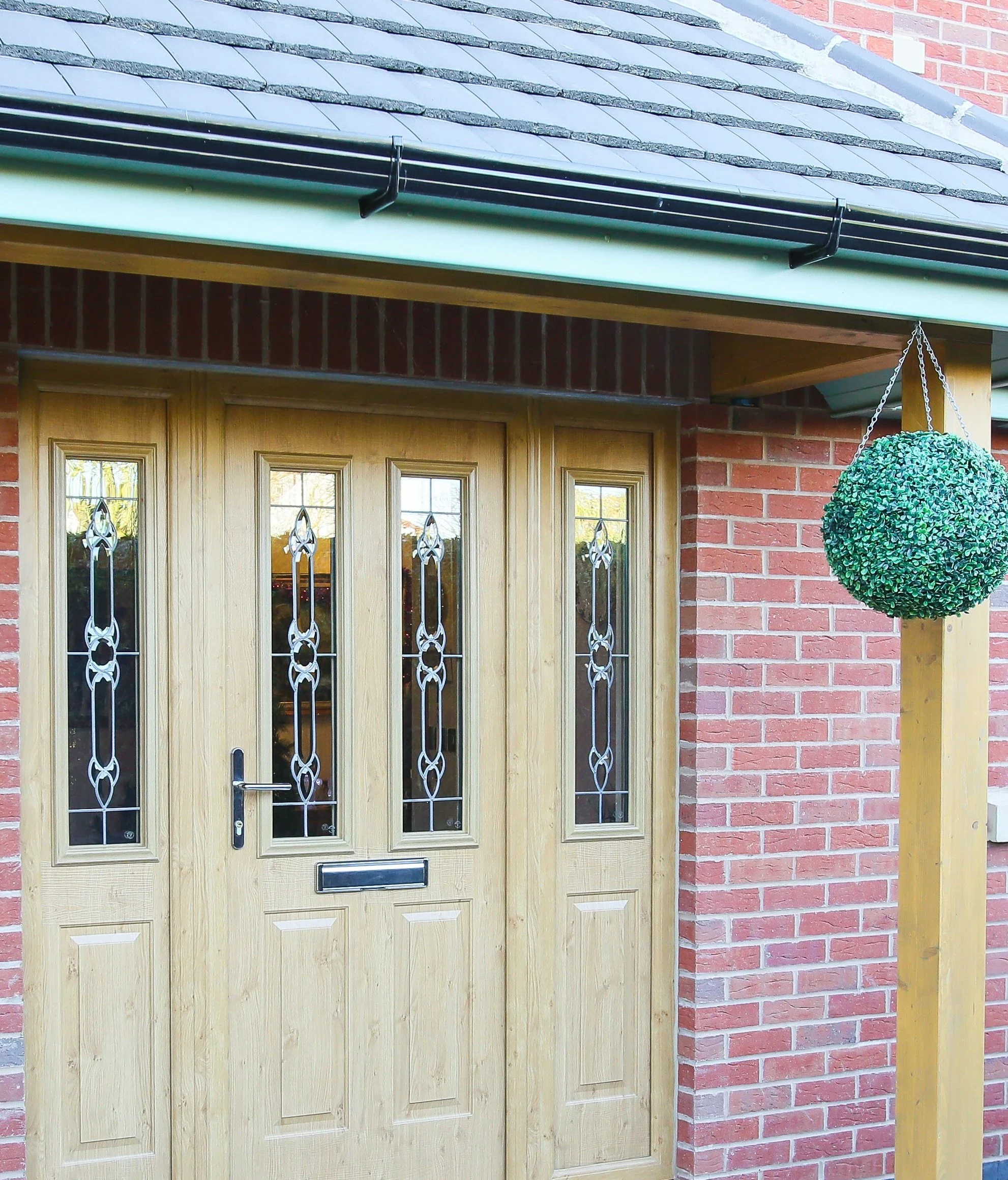 Oak-effect uPVC residential door with decorative glazing and sidelights