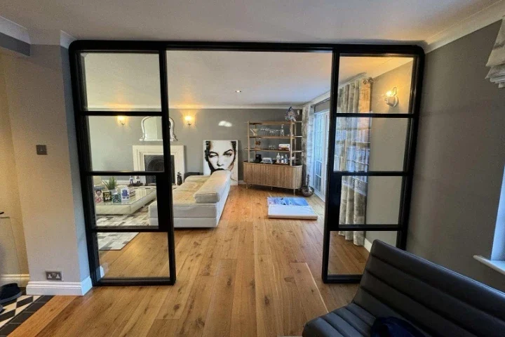 Black internal sliding double doors connecting two living spaces