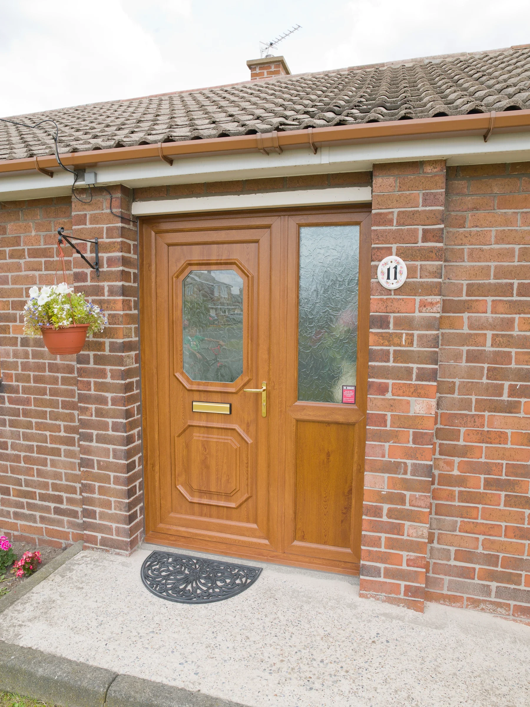 Golden oak-effect uPVC residential door with glazed sidelights