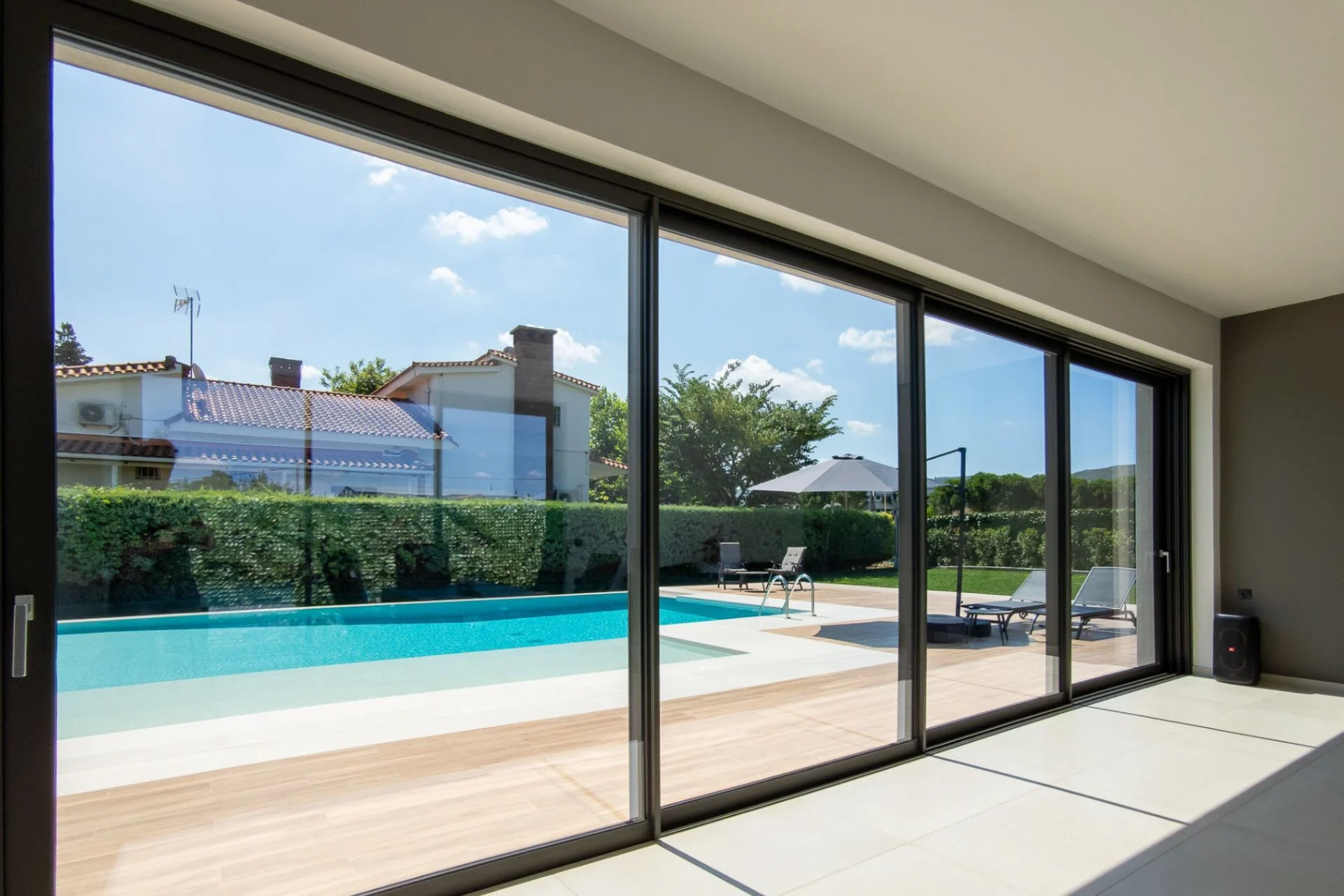 Slim aluminium sliding doors beside a swimming pool