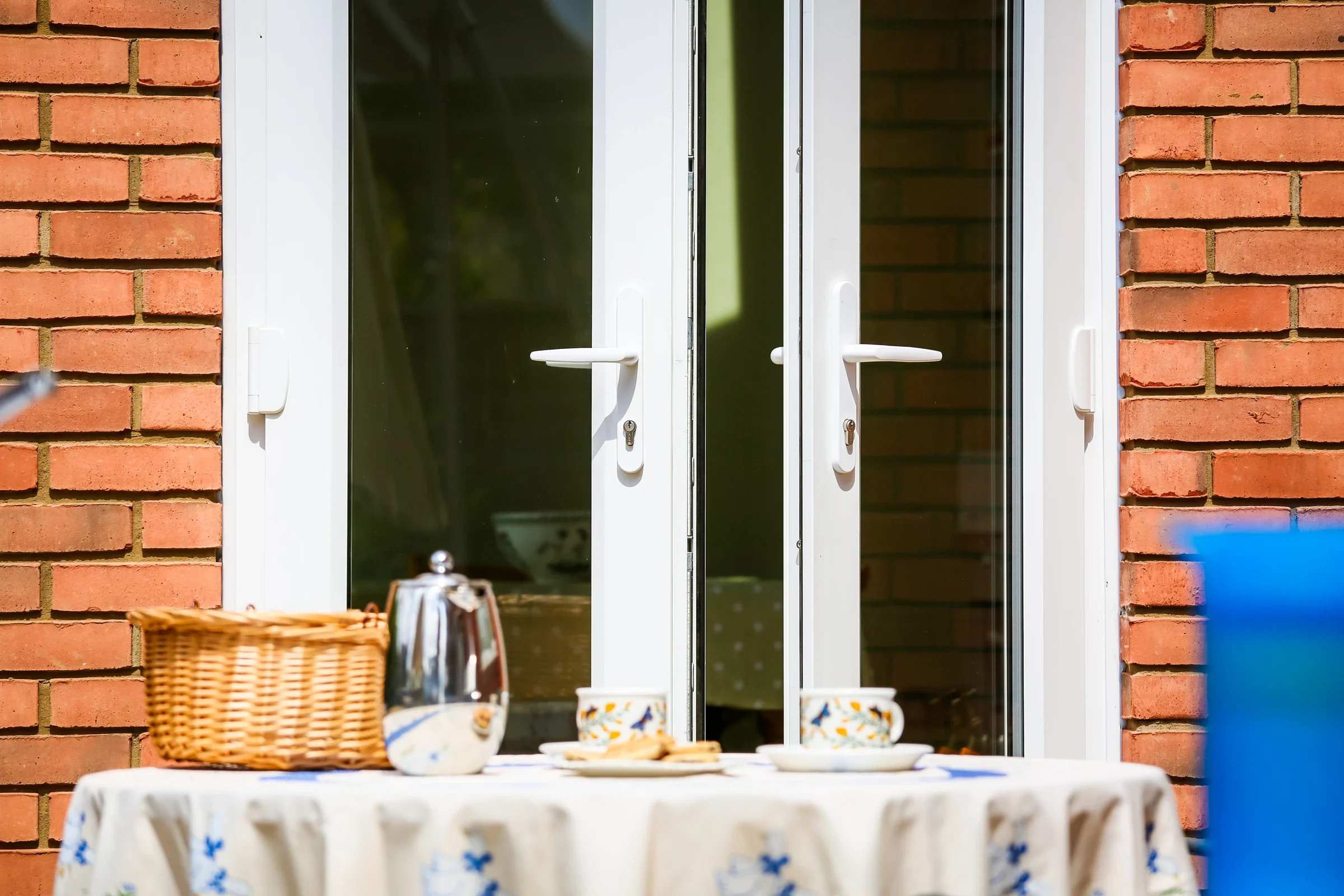 White uPVC French doors beside a sunny garden patio
