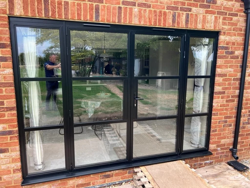 Black heritage aluminium French doors installed in a brick house
