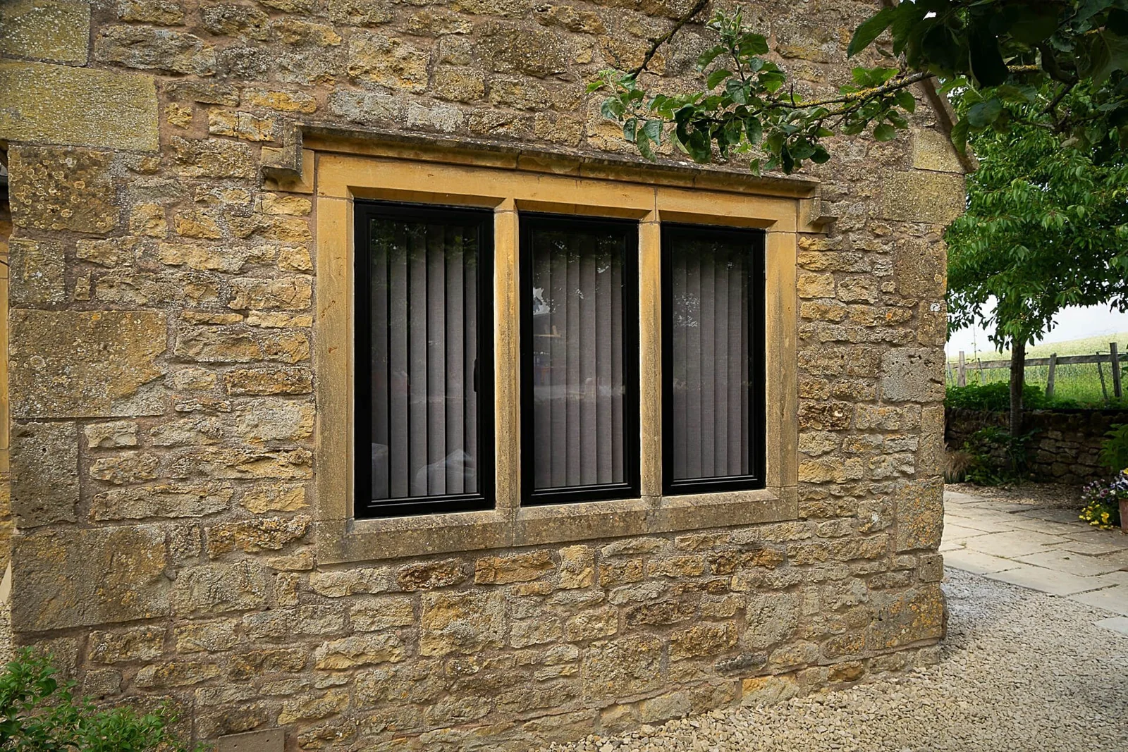Dark heritage-style aluminium windows set into stone walls