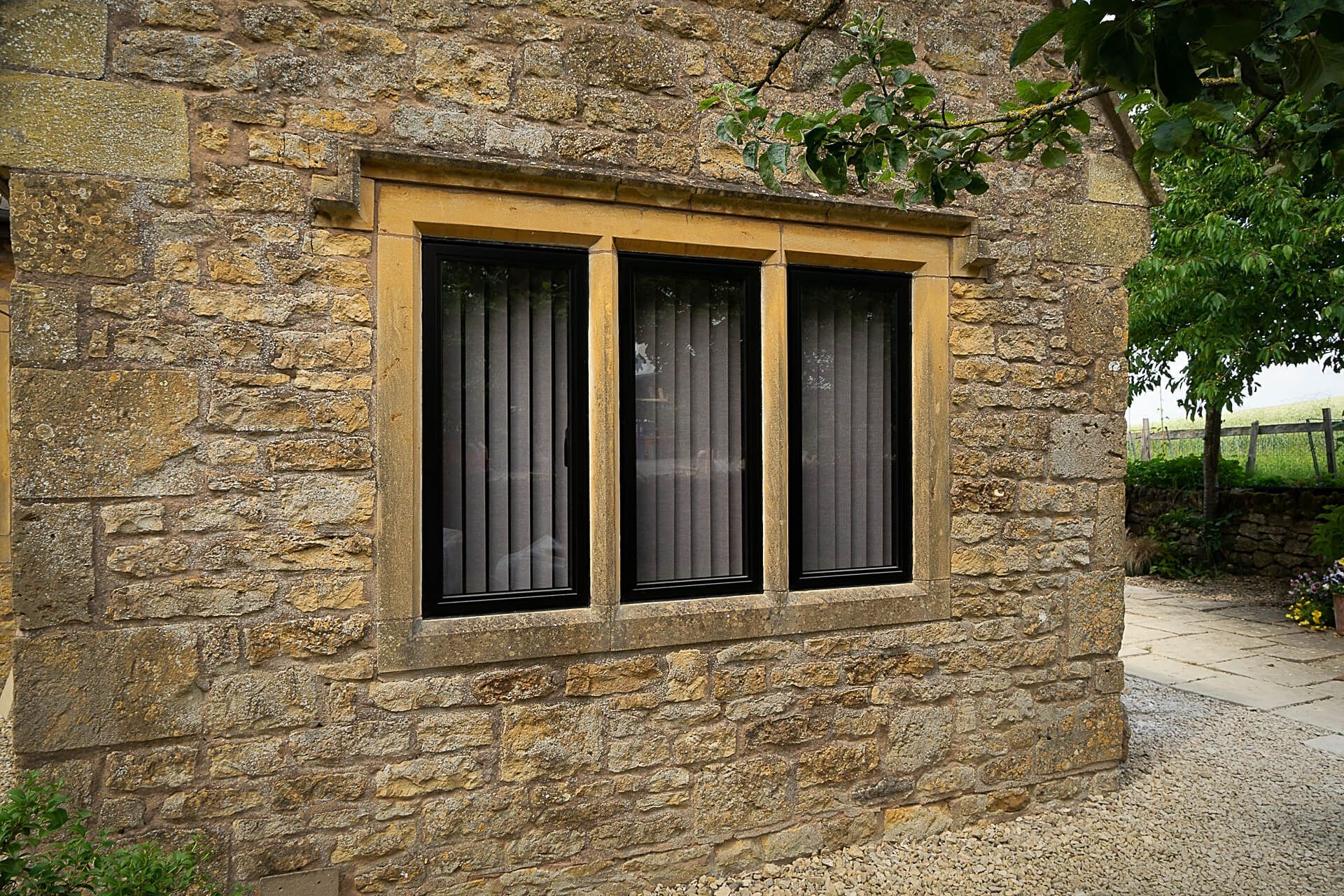Dark aluminium windows set into the stone walls of a country property
