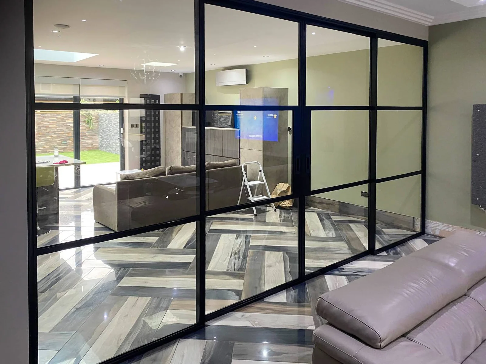 Black internal sliding doors dividing furnished rooms in an Ilford home