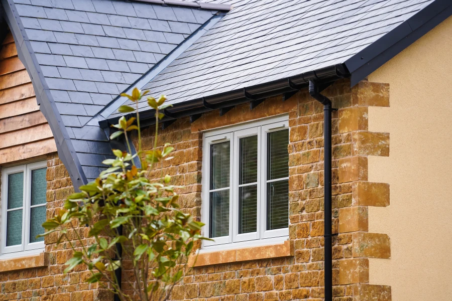Agate-grey flush uPVC windows in a stone and timber-clad home