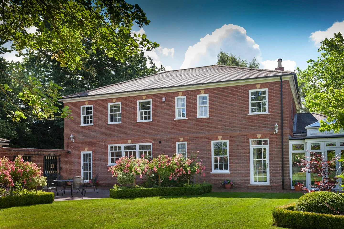 White uPVC sliding sash windows on a red-brick British country house